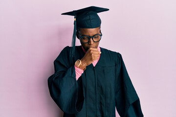 Young african american girl wearing graduation cap and ceremony robe feeling unwell and coughing as symptom for cold or bronchitis. health care concept.