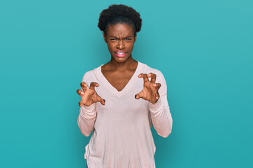 Young african american girl wearing casual clothes smiling funny doing claw gesture as cat,...