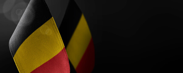 Small national flags of the Belgium on a dark background