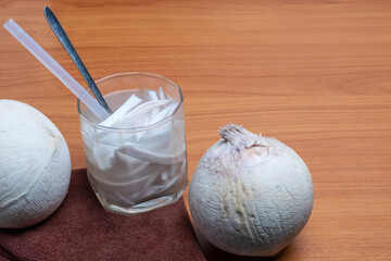 Fresh coconut juice with coconut white meat on wooden background