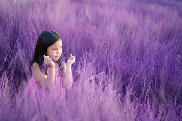 Asian child cute or kid girl lovely smile and make two finger hand mini heart for love valentine day or wedding happy with wearing pink dress on garden meadow or purple grass and violet lavender field