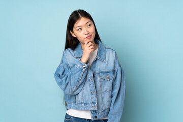 Young asian woman isolated on background and looking up