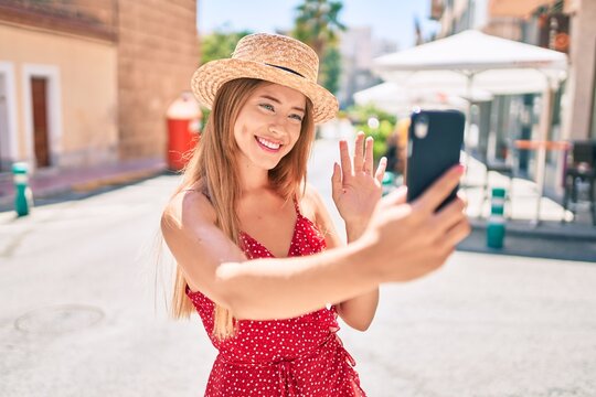 Young caucasian tourist girl smiling happy doing video call using smartphone at the city.
