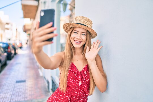 Young caucasian tourist girl smiling happy doing video call using smartphone at the city.