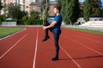 Obraz premium Handsome guy doing stretching during workout