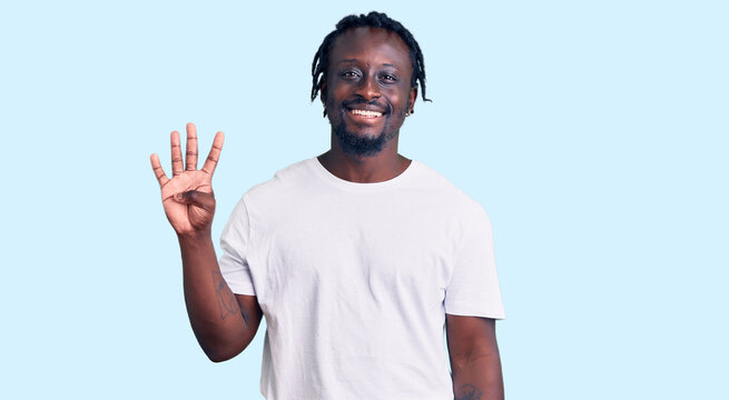 Young african american man with braids wearing casual white tshirt showing and pointing up with fingers number four while smiling confident and happy.