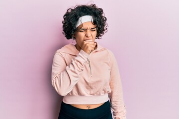 Fototapeta na wymiar Young hispanic woman with curly hair wearing sportswear feeling unwell and coughing as symptom for cold or bronchitis. health care concept.