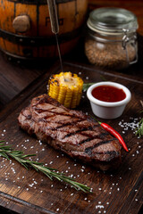 Sirloin grilled corn  on a dark wooden board, recipe magazine photo