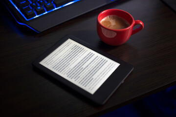 The person is reading the digital book while drinking coffee.