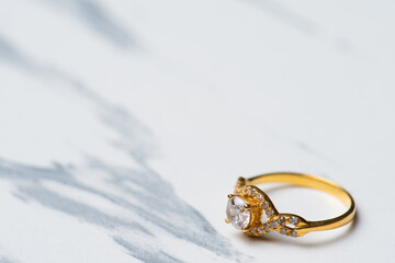 a golden wedding ring with diamond on white background