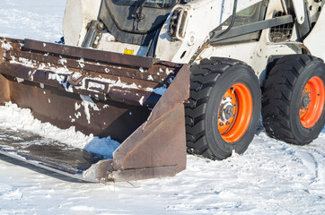 Bulldozer snow removal, close-up of excavator bucket cleaning the road for the machine.