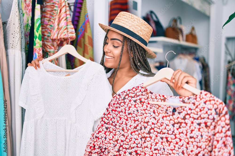 Wall mural Young african american woman smiling happy at retail shop