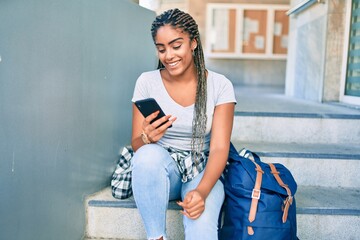 Young african american student woman smiling happy using smartphone at the university campus