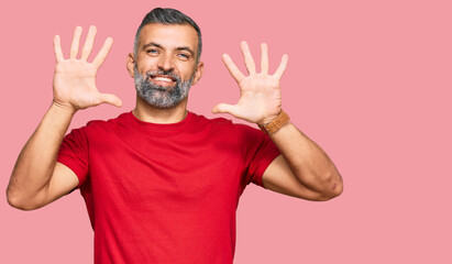 Middle age handsome man wearing casual clothes showing and pointing up with fingers number ten while smiling confident and happy.