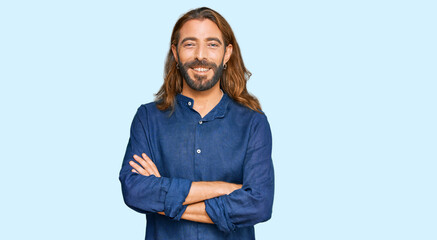 Attractive man with long hair and beard wearing casual clothes happy face smiling with crossed arms looking at the camera. positive person.