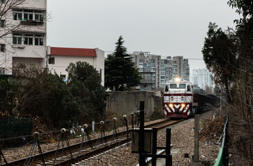 Train runs on railroad tracks of historic Shanghai–Woosung or Songhu railway of standard-gauge in...