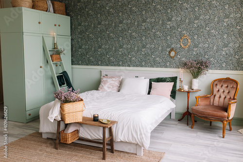 Fototapete Bedroom In Green Scandinavian Style Wardrobe With Baskets For Things Bed With Pink And Green Pillows Table With Candles And Dried Flowers Vintage Brown Armchair Anna Avramenko