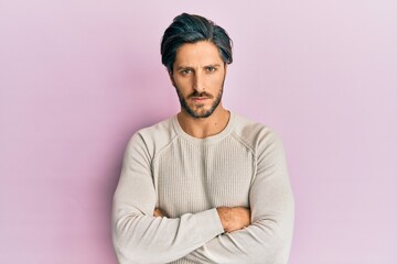 Fototapeta premium Young hispanic man wearing casual winter sweater skeptic and nervous, disapproving expression on face with crossed arms. negative person.