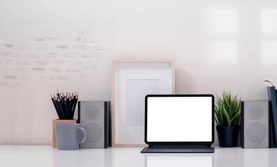 Mockup creative workspace with blank screen tablet and magic keyboard on white table.