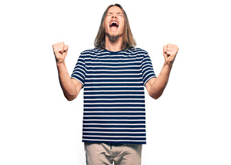 Handsome caucasian man with long hair wearing casual striped t-shirt celebrating mad and crazy for...