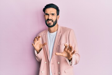 Young hispanic man wearing business jacket disgusted expression, displeased and fearful doing disgust face because aversion reaction. with hands raised