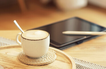 cozy scene with a cup of coffee and a tablet on a wooden table