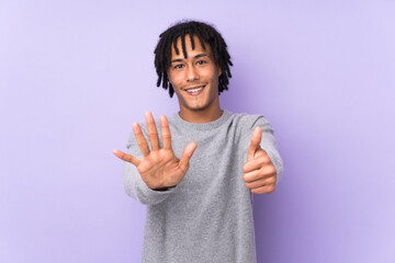 Young african american man isolated on purple background counting six with fingers