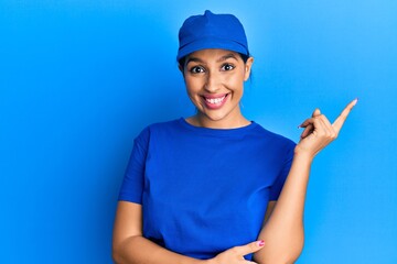 Beautiful brunette woman wearing delivery uniform smiling happy pointing with hand and finger to the side