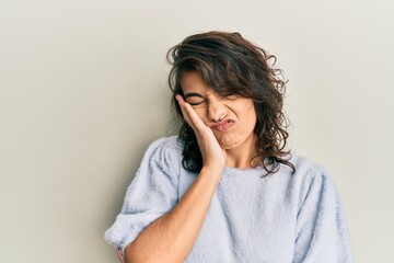 Young hispanic woman wearing casual winter sweater thinking looking tired and bored with depression problems with crossed arms.