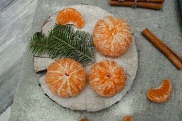 Flat lay Christmas composition with fresh tangerines and fir tree branches on grey background. Space for text