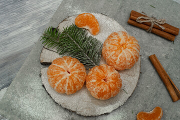 Flat lay Christmas composition with fresh tangerines and fir tree branches on grey background. Space for text