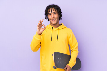 Handsome young skater man over isolated wall showing ok sign with fingers