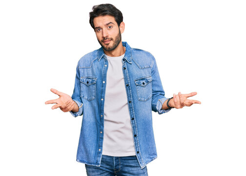 Young hispanic man wearing casual clothes clueless and confused with open arms, no idea concept.
