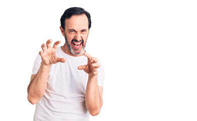 Middle age handsome man wearing casual t-shirt smiling funny doing claw gesture as cat, aggressive and sexy expression