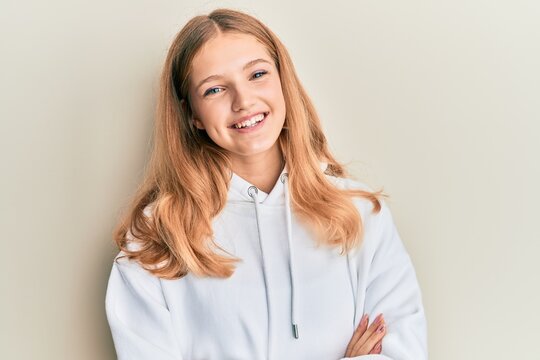 Beautiful young caucasian girl wearing casual sweatshirt happy face smiling with crossed arms looking at the camera. positive person.