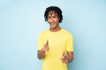 Young african american man isolated on blue background pointing to the front and smiling