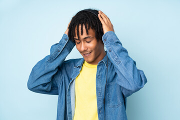 Young african american man isolated on blue background listening music