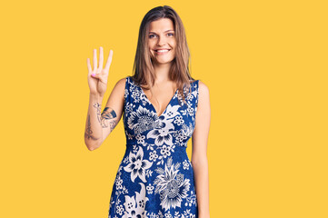 Beautiful caucasian woman wearing summer dress showing and pointing up with fingers number four while smiling confident and happy.