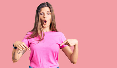 Beautiful caucasian woman wearing casual clothes pointing down with fingers showing advertisement, surprised face and open mouth