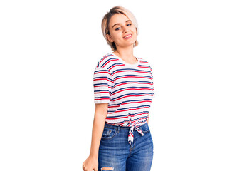 Obraz premium Young beautiful blonde woman wearing casual clothes looking positive and happy standing and smiling with a confident smile showing teeth