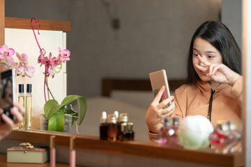 Selective focus. Happy smiling girl takes a selfie in front of the mirror. Blurred image
girl talking on a video call on the phone while sitting in front of the mirror.