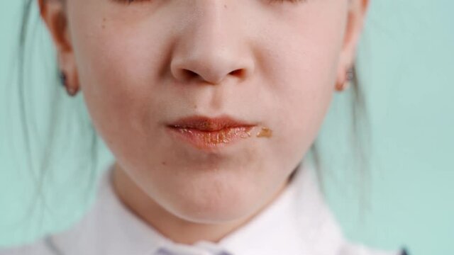 A young girl eats milk chocolate.