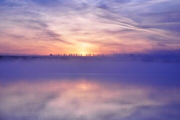 Fototapeta premium Misty beautiful sunrise over water