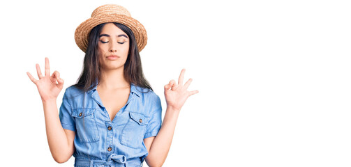 Brunette teenager girl wearing summer hat relax and smiling with eyes closed doing meditation...