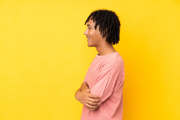 Young african american man isolated on yellow background in lateral position