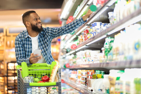 Black Male Shopping Groceries In Supermarket Taking Product From Shelf