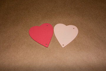 Two hearts, pink and red on craft paper.