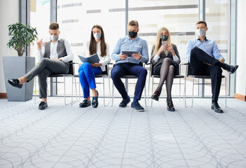 Stressful business people waiting for job interview with face mask, social distancing quarantine during COVID19 affect.