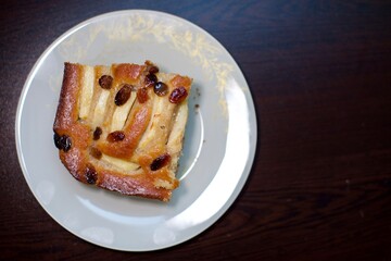 piece of cake with raisins and apples with natural light near the window. blurry view

