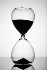Sand moves through hourglass. Close up of hour glass clock. Old time classic sandglass timer. Hourglass as time passing concept for business deadline, urgency and running out of time